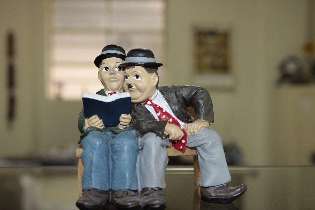 Lowell and Hardy figurines reading a book